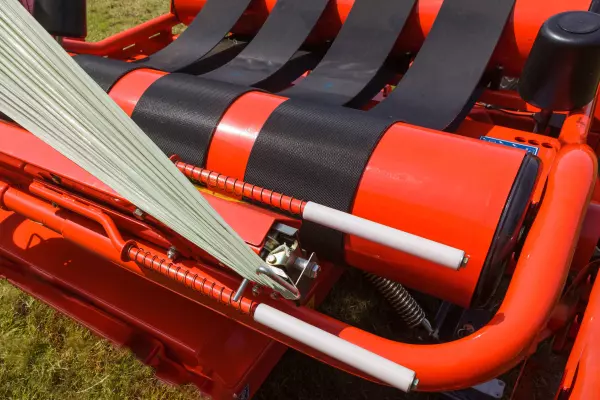 Um cortador de filme de alta aderência carregado por mola segura e corta o filme automaticamente.