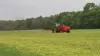 SL 124 bem distante espalhando esterco em um campo.